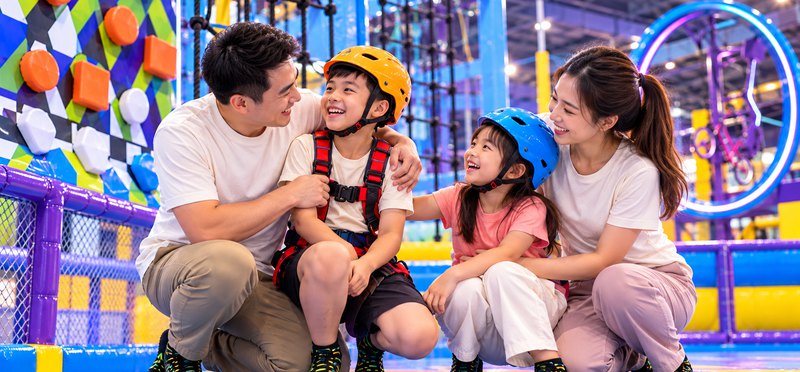 Bố mẹ và hai con vui vẻ bên nhau ở khu vui chơi